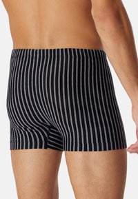 Sorte og hvide stribede boxershorts med en tætsiddende pasform, behagelig linning og glat, strækbart stof.