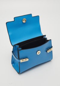 Blue crocodile-embossed handbag with a gold snap closure, black interior, and gold accents. Features a structured shape and two compartments.