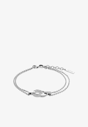 Silberarmband mit zwei ineinander greifenden Gliedern, von denen eines mit klaren Steinen verziert ist, an einer doppelten Kette. Es enthält einen Verschluss sowie ein rechteckiges Tag, das mit "Jette" geprägt ist.