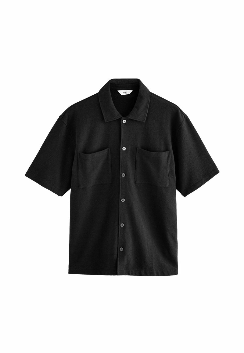 Chemise noire à manches courtes avec boutons sur le devant, deux poches poitrine et un col classique, présentée sur un fond blanc.