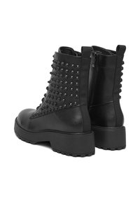 Czarne skórzane botki do kostki o fakturowanym wykończeniu, z ćwiekami po bokach, masywną podeszwą oraz zamkiem błyskawicznym ułatwiającym zakładanie.