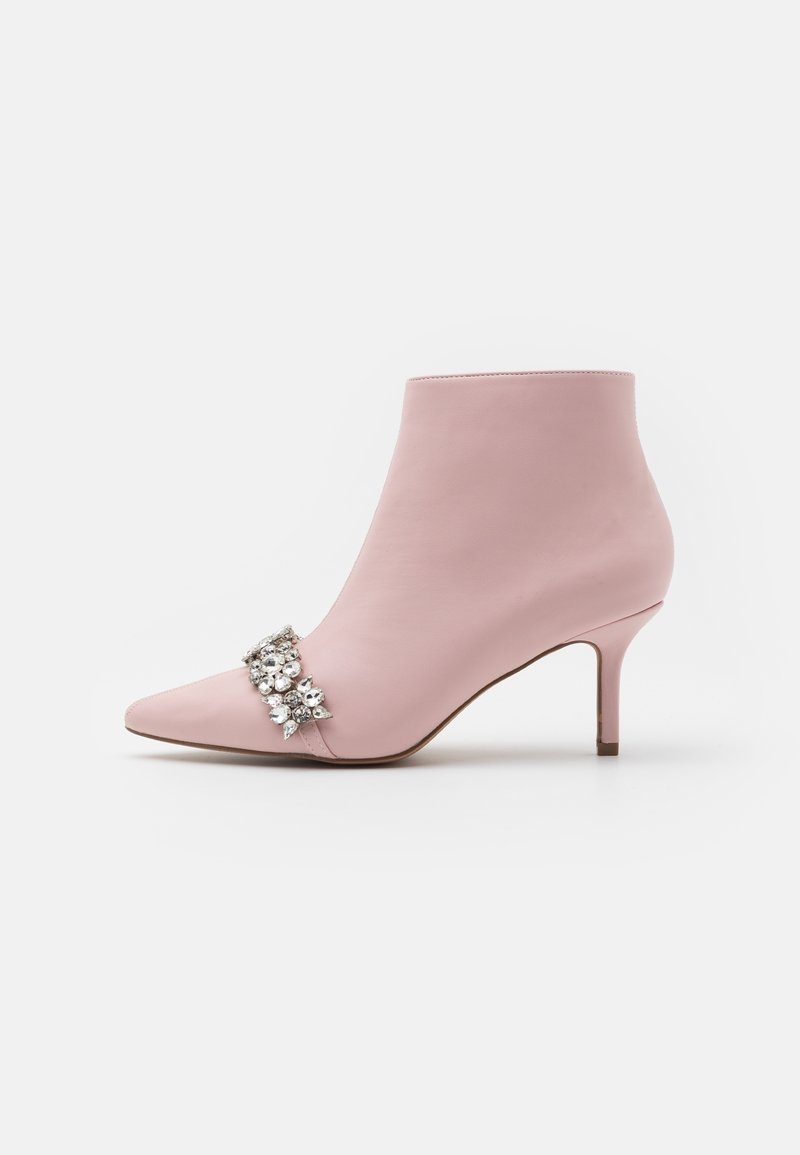 Bottine rose à bout pointu avec talon stiletto bas et décoration florale en bijoux argentés sur le devant.