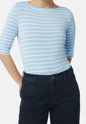 Niebieska i biała bluzka w paski z rękawami do łokcia, wykonana z lekkiego materiału, w zestawieniu z ciemnoniebieskimi dżinsami z zapięciem na guzik.