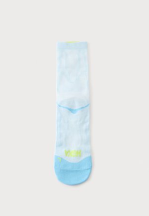 Enkele witte sok met lichtblauwe teen- en hielzones, geel "Hoka" logo en blauw detail voor boogondersteuning op een effen witte achtergrond.
