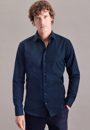 Langärmliges Navyblaues Hemd mit Knopfleiste aus glattem Stoff, mit klassischem Kragen und passenden Knöpfen, auf einem neutralen Hintergrund präsentiert.