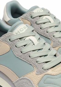 Zapatillas de color azul claro y beige con materiales de malla, ante y cuero. Punta redondeada, detalles texturizados y cordones planos.