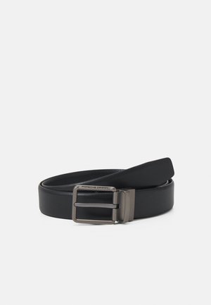 Ceinture synthétique noire au fini texturé, dotée d'une boucle en métal matte portant l'inscription "Porsche Design." Longueur ajustable avec un bord lisse.