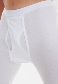 White cotton boxer briefs with a soft waistband, featuring a contour pouch and smooth texture. Straight cut with subtle stitching details.