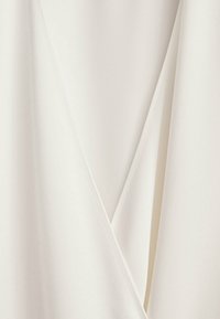 Tessuto bianco con una superficie liscia, caratterizzato da una caduta diagonale e una sottile lucentezza, creando un aspetto pieghettato all'escursione.