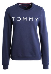 Mörkblå långärmad sweatshirt med vit "TOMMY"-text över bröstet, ribbade ärmslut och fåll, rund hals med inre röda och vita ränder.
