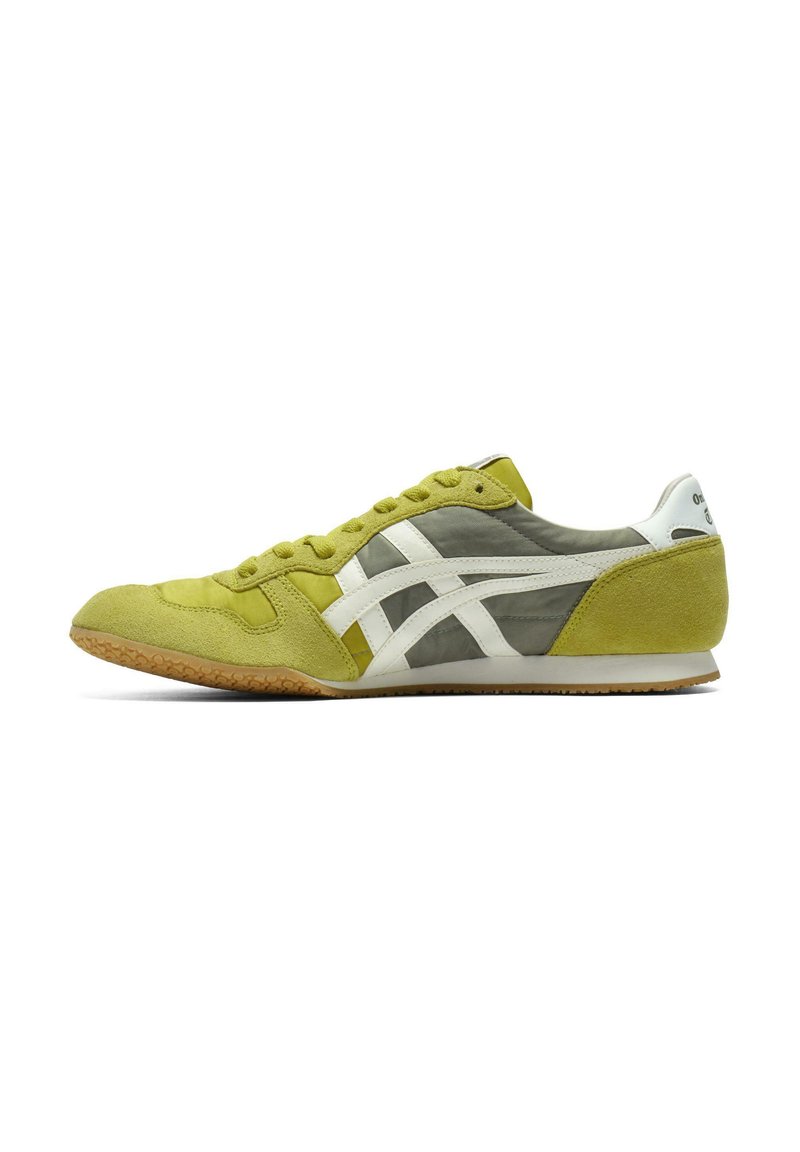 Scarpa sportiva bassa con una combinazione di suede verde brillante e pannelli in rete grigi, strisce bianche e una suola in gomma naturale.