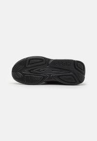Sole di scarpa sportiva nera con gomma testurizzata, caratterizzata da un motivo di battistrada distintivo e un marchio in rilievo. Elementi di design durevoli e flessibili.