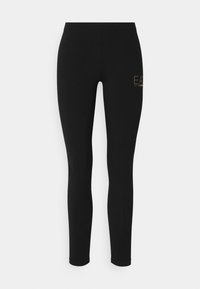 Zwarte legging met een slim fit, gemaakt van rekbaar materiaal, met een gouden logo aan de linkerkant. Gladde textuur, volledig lange ontwerp.