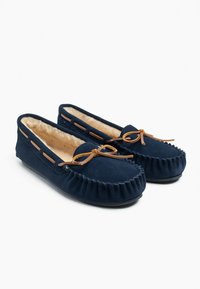 Marineblaue Wildleder-Mokassins mit einem weichen Fellfutter, Lederbindemöglichkeiten und gerafften Details an der Schuhspitze und den Seiten. Flache Gummisohlen.
