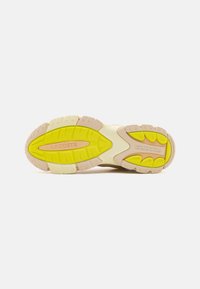 Lacoste sneaker talpa bézs és sárga színben. Textúrázott gumi, bordázott felülettel, középen kiemelkedő logóval. Ívelt formatervezési elemek.