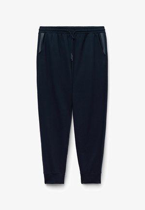 Granatowe dresy z elastycznym pasem, sznurkiem, bocznymi kieszeniami i ściągaczami na końcach. Gładki materiał z luźnym krojem.