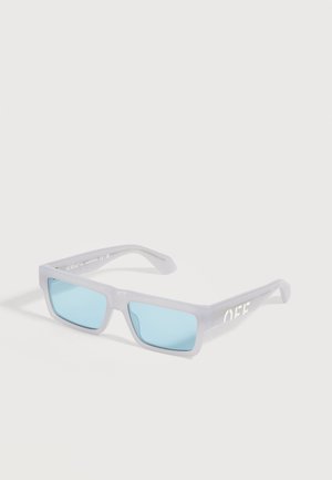 Lunettes de soleil rectangulaires avec verres bleu clair et monture grise translucide ornée du texte blanc "OFF" sur la branche.