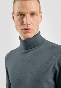 Sweter z golfem w ciemnoszarym kolorze, dzianinowy materiał, dopasowany krój, ściągacz przy kołnierzu, długie rękawy, minimalna tekstura, blisko przylegająca konstrukcja.