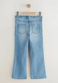 Pantalons en denim bleu clair à jambe large, dotés d'une taille froncée et de deux poches arrière dans un design classique.