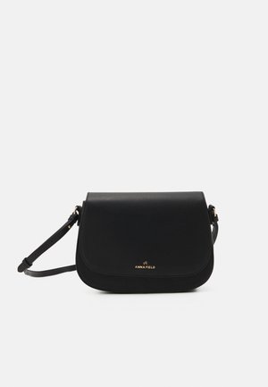 Czarna skórzana torebka crossbody z zaokrągloną klapą, złotym detalem z logo, regulowanym paskiem i gładką teksturą.