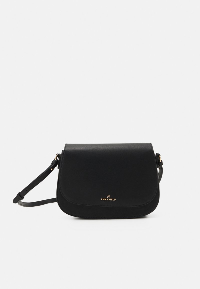 Borsa a tracolla in pelle nera con chiusura a pattina curvata, dettaglio logo dorato, tracolla regolabile e texture liscia.