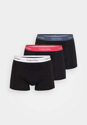Tres pares de bóxers negros con cinturas de colores variados: una blanca, una rosa y una gris. Todos incluyen la marca "Calvin Klein" en las cinturas.