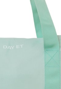 Mintgroene schoudertas met een gladde textuur, voorzien van een gestikte strap en het "DAY ET" logo in het wit. Accenten omvatten kruissteekdetails.