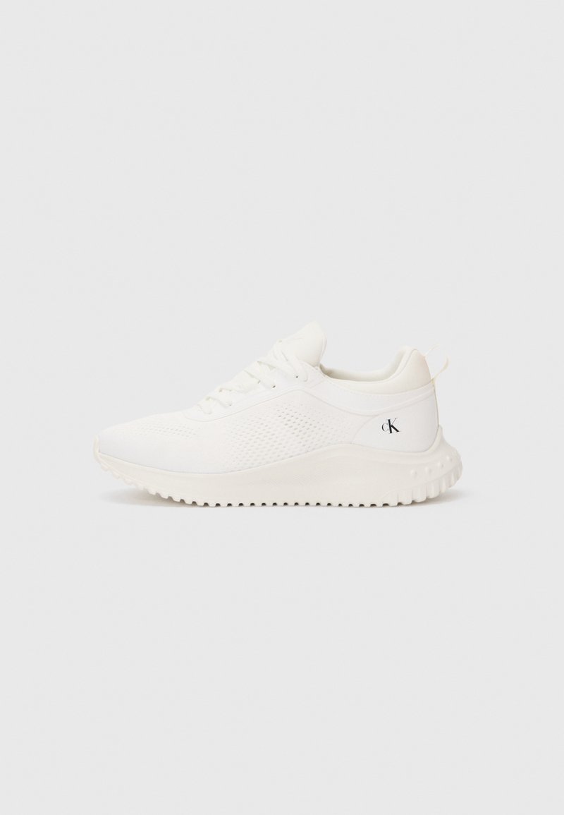 Baskets blanches de sport avec semelle texturée, design à lacets, côtés en mesh respirant et petit logo "cK" sur le contrefort du talon.