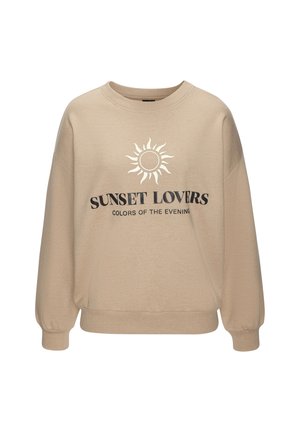 Beige Oversize-Sweatshirt mit langen Ärmeln, versehen mit einem Sonnen-Design und dem Text "SUNSET LOVERS" in Schwarz. Weicher Stoff mit gerippten Bündchen.