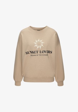 Beige Oversize-Sweatshirt mit langen Ärmeln, versehen mit einem Sonnen-Design und dem Text "SUNSET LOVERS" in Schwarz. Weicher Stoff mit gerippten Bündchen.