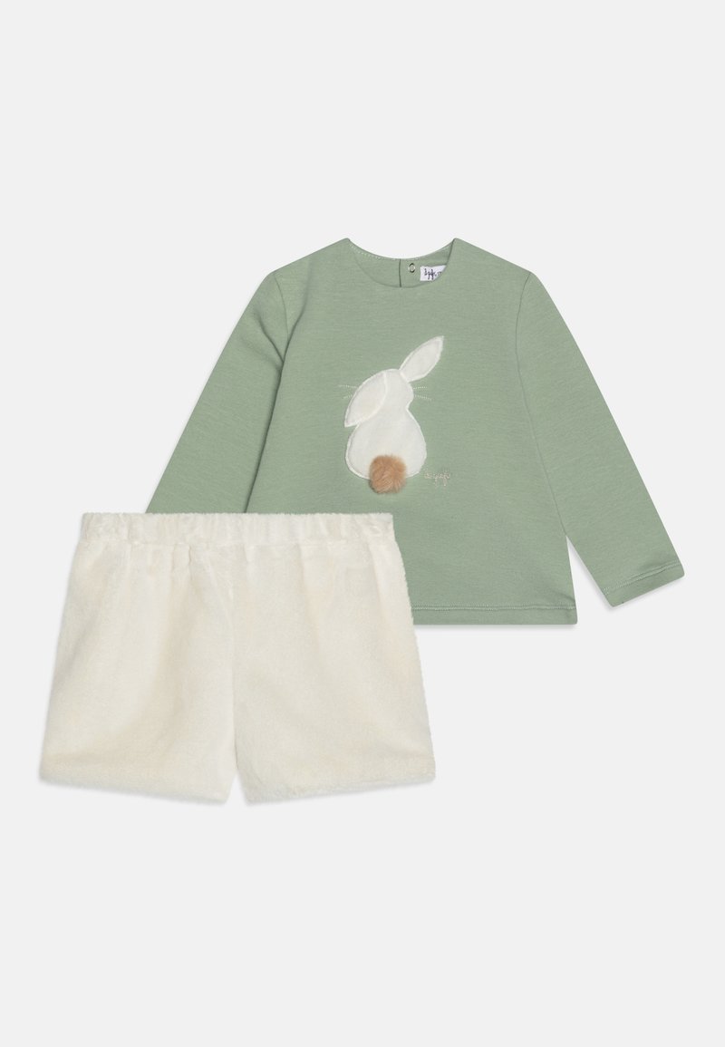 Green long-sleeve top with bunny applique and white furry shorts. The outfit features soft textures and a relaxed fit design.