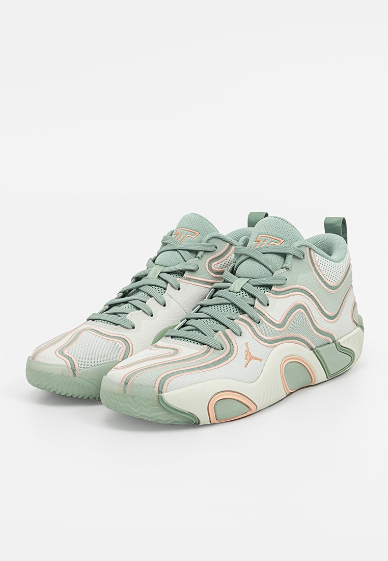 Scarpe sportive verde chiaro con un design a onde, caratterizzate da una parte superiore in mesh, inserti testurizzati e una suola in gomma. Dettagli neri e pesca visibili.