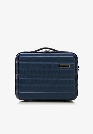 Valigia rigida navy con scanalature orizzontali, dettagli neri e maniglia superiore. Presenta una placca con il logo del marchio sul fronte.