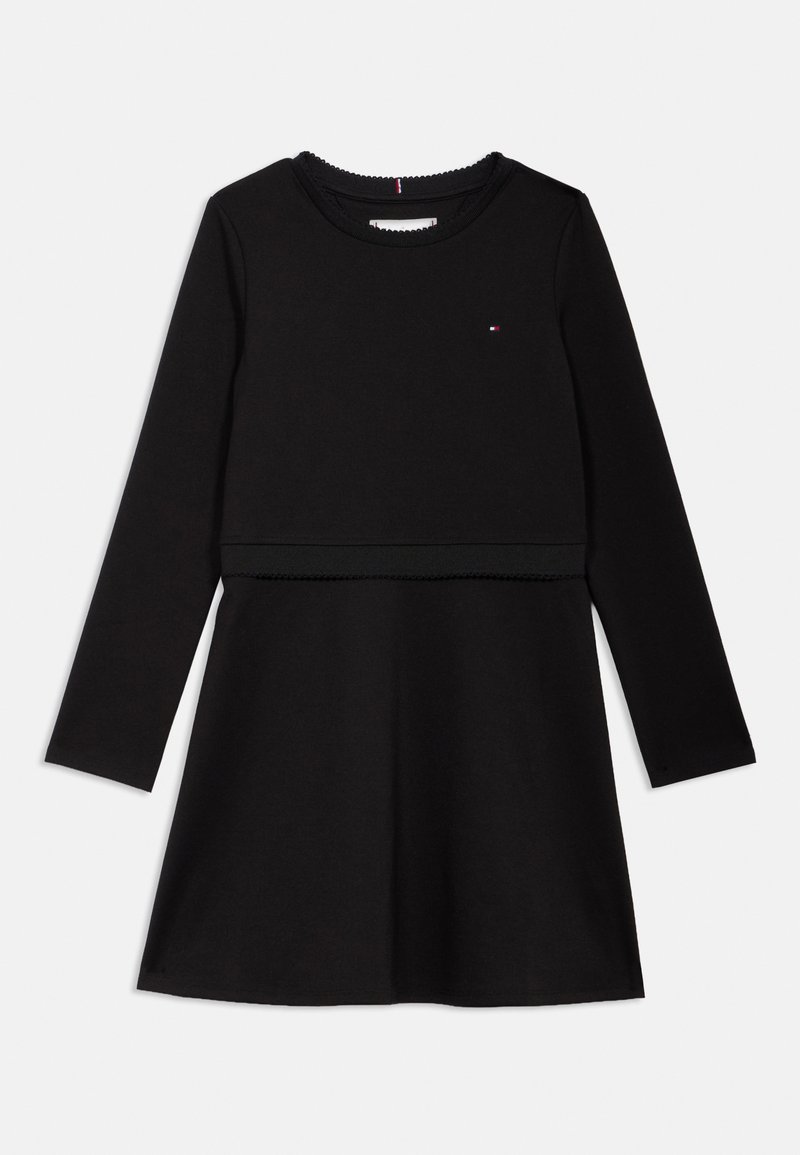 Czarna sukienka z długim rękawem wykonana z bawełny, z dopasowanym gorsetem, rozkloszowanym dołem i falbaniastym dekoltem z małym logo na klatce piersiowej.