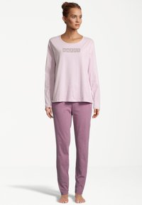 Pink long-sleeve shirt with "HAPPY" lettering, paired with light pink pants. Both made from soft, comfortable fabric. Simple design.