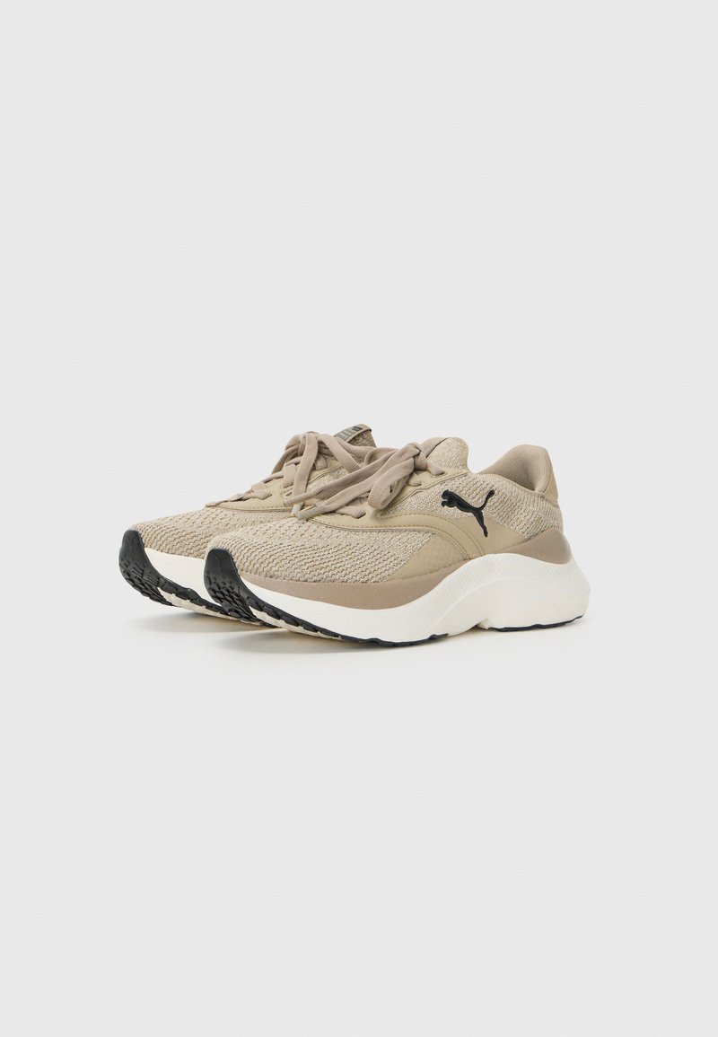 Zapatillas beige con un upper texturizado, puntera redonda y cordones planos. Presentan una entresuela blanca y una suela de goma negra con tracción.