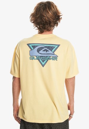 Light yellow short-sleeve t-shirt with a large graphic on the back in blue and black, featuring a triangular design and Quiksilver logo.