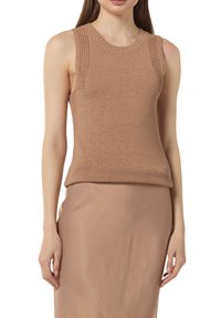 Jasnobrązowy bezrękawnik dzianinowy z okrągłym dekoltem i fakturowanymi detalami na ramionach, w połączeniu z gładką, jasnobrązową spódnicą.