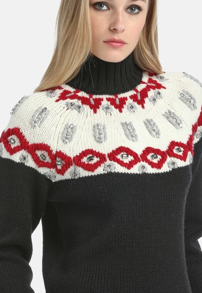 Melna adīta turtleneck džemperis ar baltiem, sarkaniem un sudraba rakstiem ap kaklu. Iezīmējas ar strukturētām šuvēm un rotājumiem dizainā.