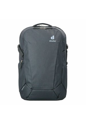 Mochila de color gris oscuro con acabado de tela suave, diseño angular, cremalleras frontales, correas acolchadas y un logo en la parte superior.