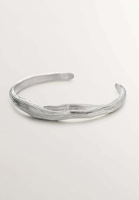 Diadema de metal plateado con un diseño ondulado y texturizado. Acabado suave con líneas horizontales elevadas que crean un aspecto natural.