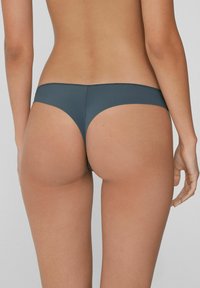 Dunkelgrauer Bikiniunterteil mit minimaler Abdeckung, glatter Textur und elastischem Bund, mit einem tiefen Schnitt und nahtlosem Design.