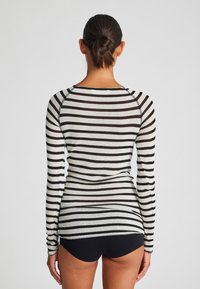 Langsleeve shirt met zwart-witte horizontale strepen. Gemaakt van lichte stof met een getailleerd ontwerp en een ronde halslijn.