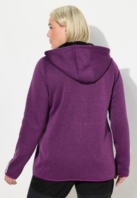 Lila Fleece-Hoodie mit strukturiertem Finish, Kapuze und seitlichen Akzentdetails. Saum und Ärmelbündchen weisen kontrastierende Farben und Designelemente auf.