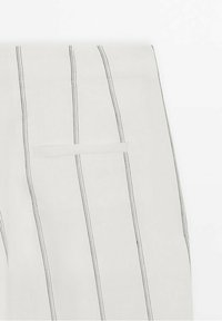 Pantalon en tissu blanc avec de fines rayures verticales grises, coupe droite, et une poche arrière avec un rabat minimaliste.