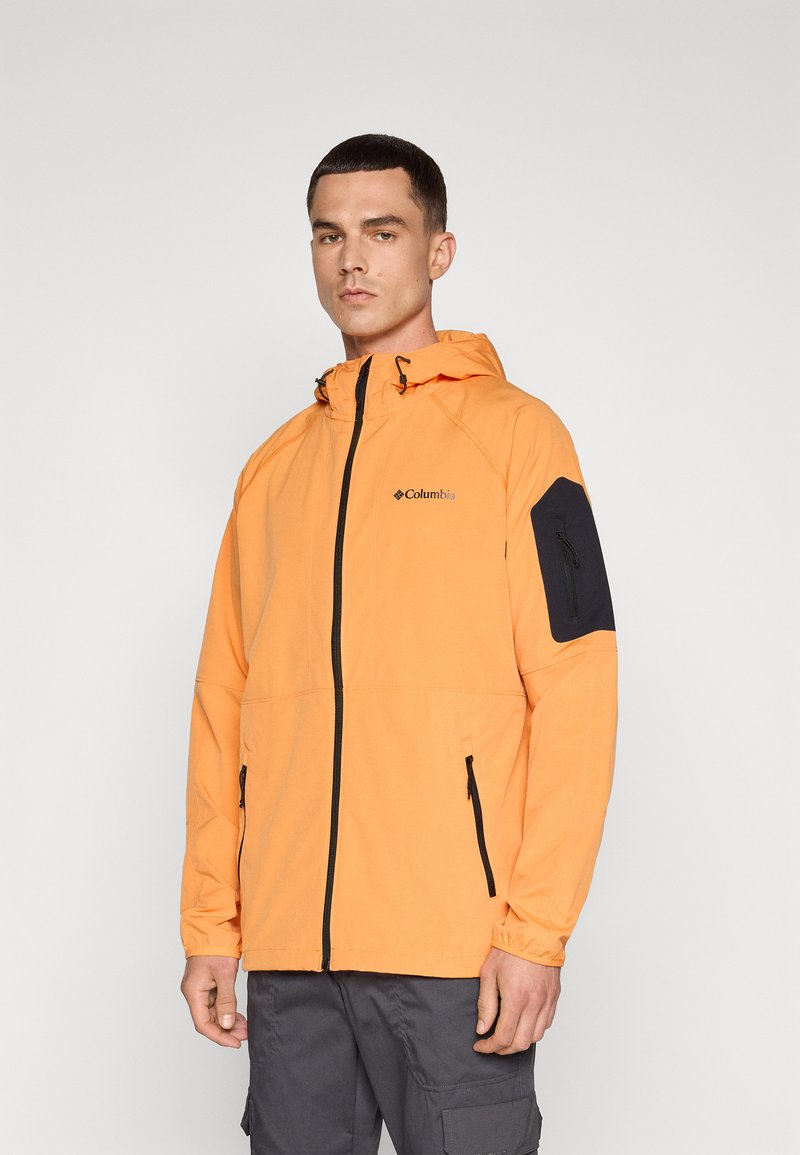 Pomarańczowa wodoodporna kurtka z zamkiem z przodu, regulowanym kapturem i czarnymi akcentami na rękawach. Posiada boczne kieszenie i elastyczne mankiety.