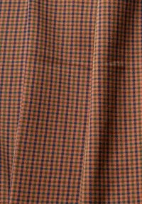 Tkanina w kratę w ciepłych kolorach pomarańczowym, niebieskim i zielonym. Charakteryzuje się ciasno tkanym teksturą i drobnym wzorem w kratkę na całej powierzchni.