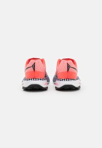 Scarpe sportive con una parte superiore in rete rosa brillante, dettagli neri e una suola bianca e nera a motivo. Presentano un tallone imbottito per il supporto.