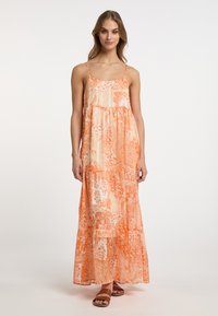 Rochie maxi dintr-un material ușor, de culoare portocalie, cu modele florale și paisley. Prezentă cu bretele subțiri și un design în straturi.