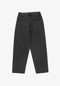 Svarta denimjeans med en avslappnad passform, med två bakfickor, en läderpatch i midjan och synliga sömmar. Tyget har en mjuk textur.